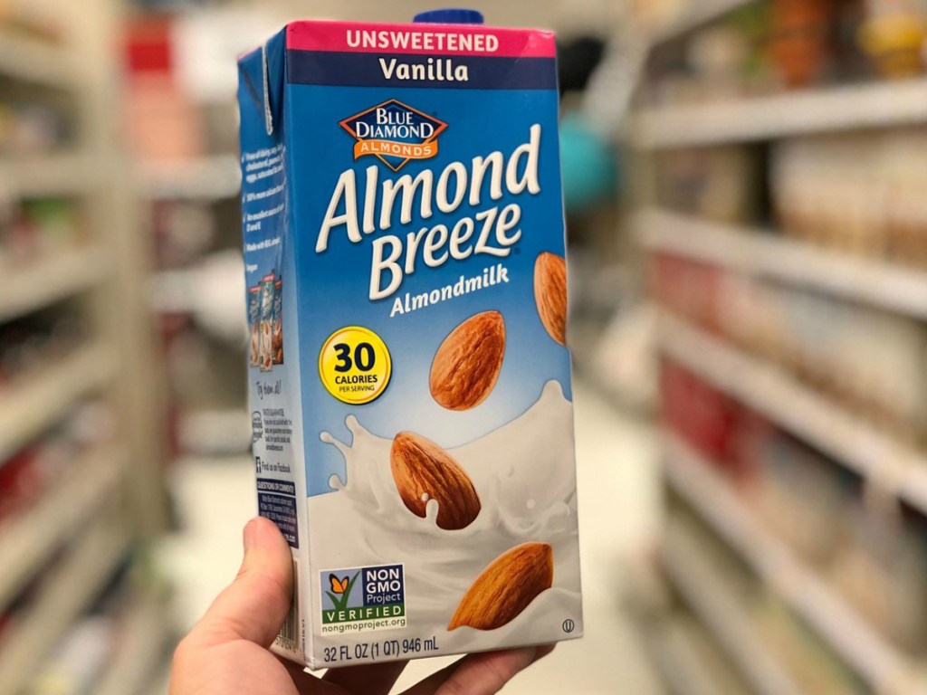 hand holding Almond milk box in store aisle