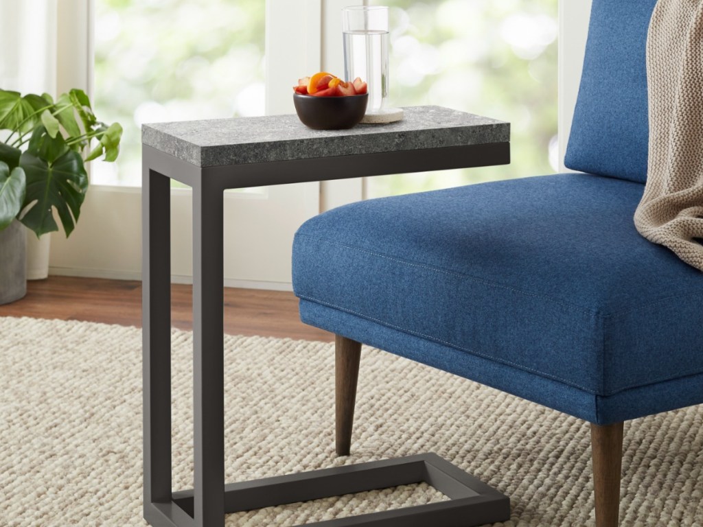 soft chair with small table that has a bowl and cup on it
