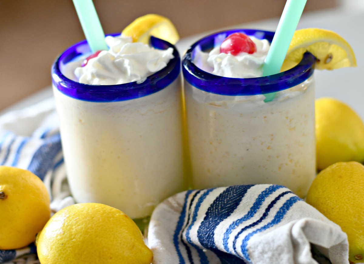 2 creamy frosted lemonades on the table with straws 