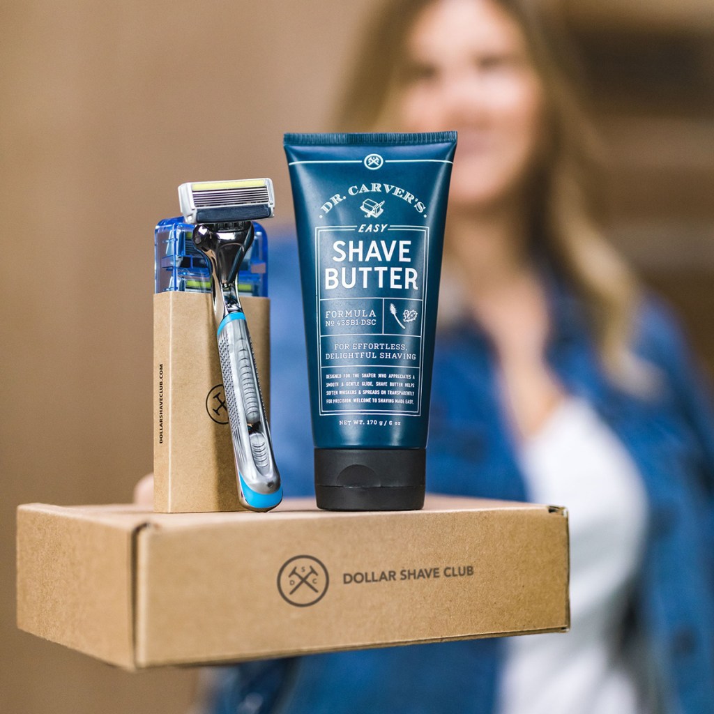 woman holding up dollar shave club box