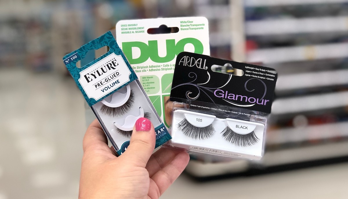 hand holding false eyelashes from Eylure, Duo, and Ardell