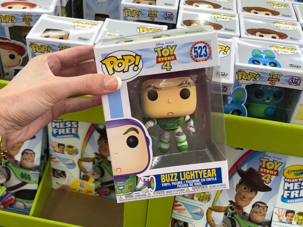 hand holding Pop toys in front of toy display