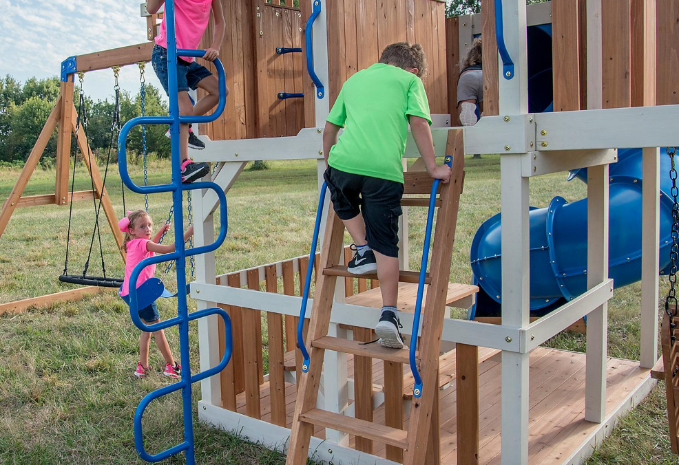 Kids climbing up ladder of Skyline Retreat All Cedar Playset