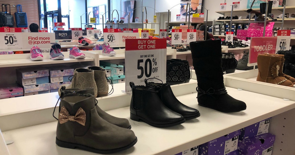 shoes and boots on shelves with sale signs inside 