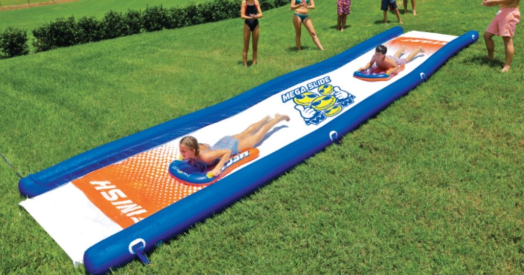 long slip and slide with kids on it in grass