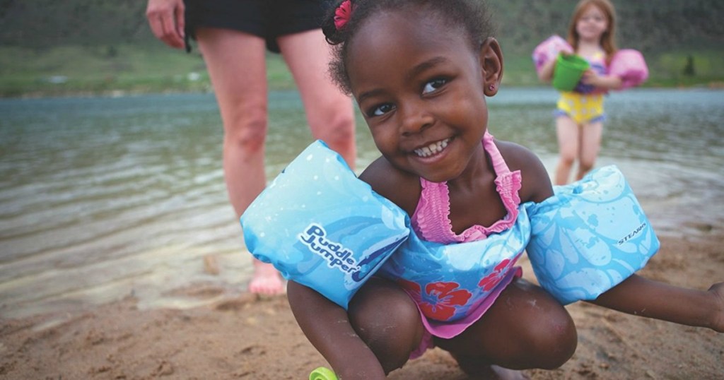 girl at the beach wearing her puddle jumper