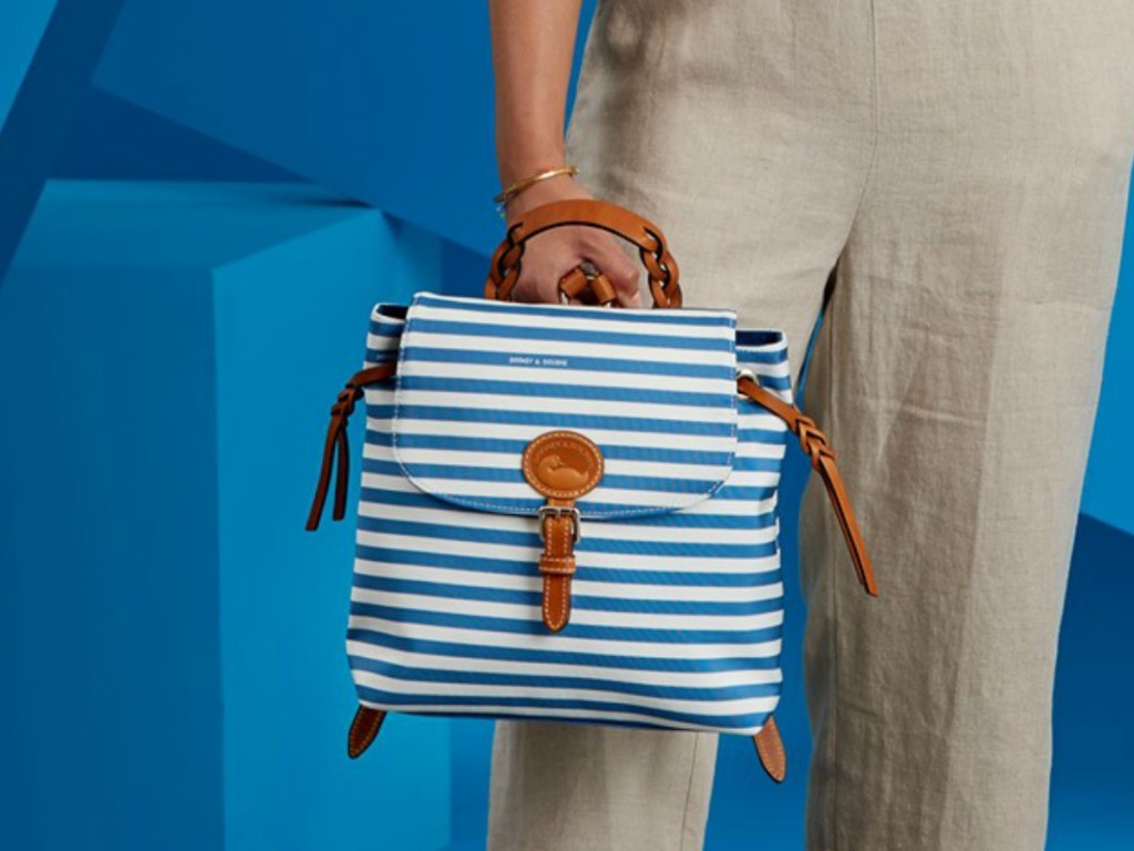 woman holding striped blue backpack