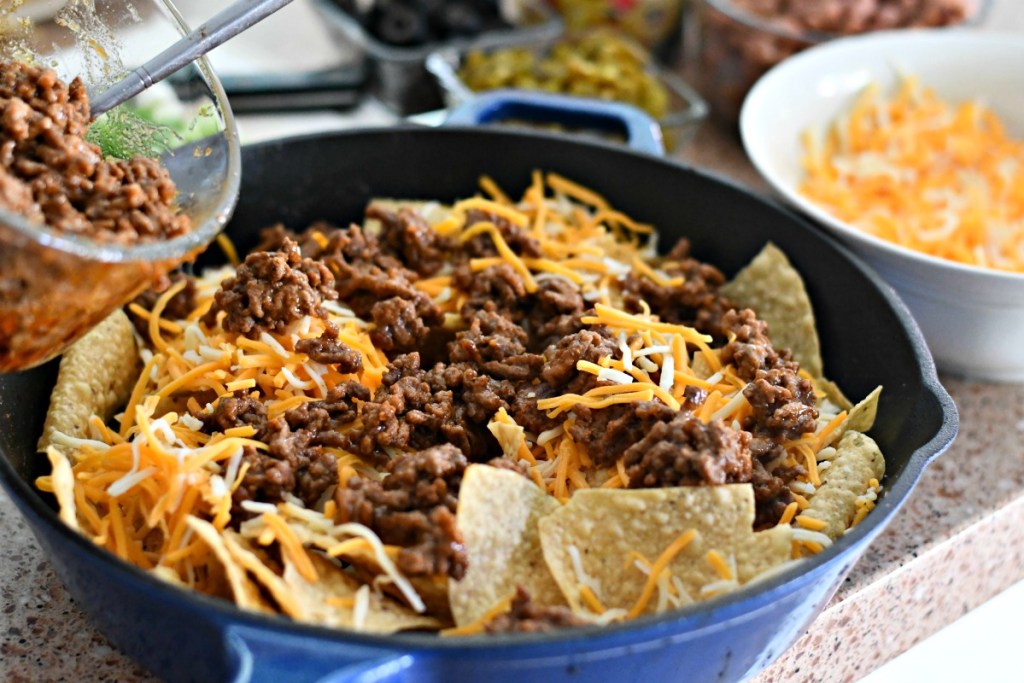 taco meat on top of skillet nachos