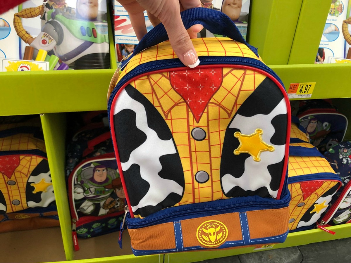 hand holding lunch box in front of kids display