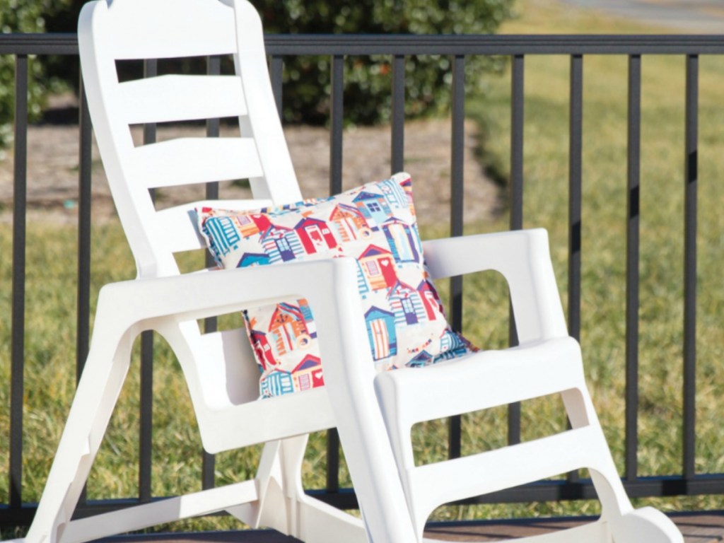 white chair on deck outside with pillow on it