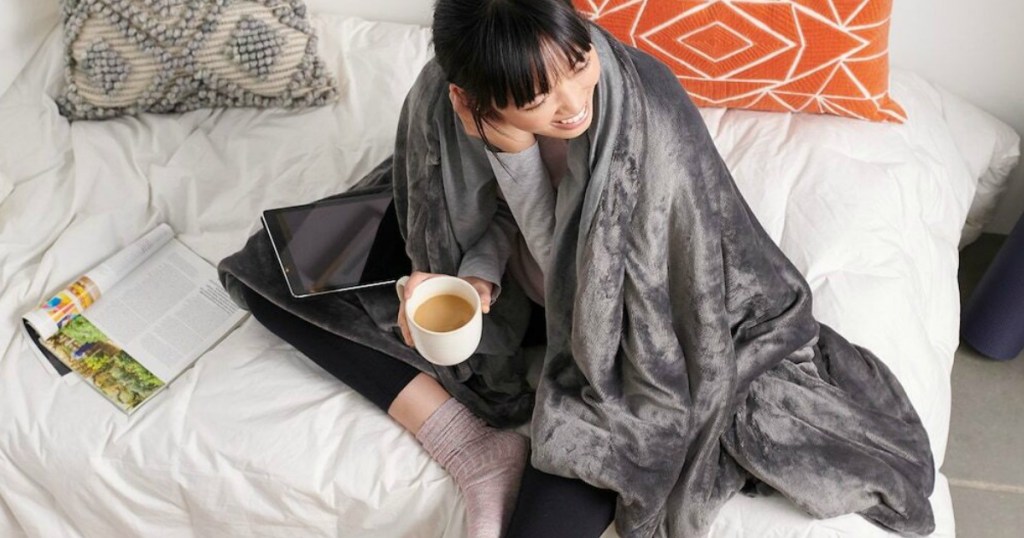 woman wrapped in blanket drinking coffee