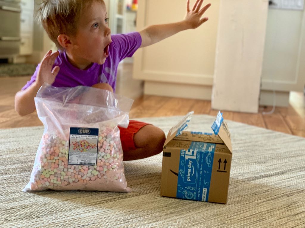little boy with big bag of marshmallow bits and Amazon Prime box
