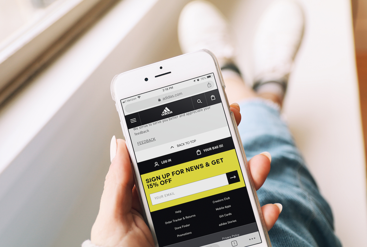 Closeup of woman holding iPhone with adidas deals