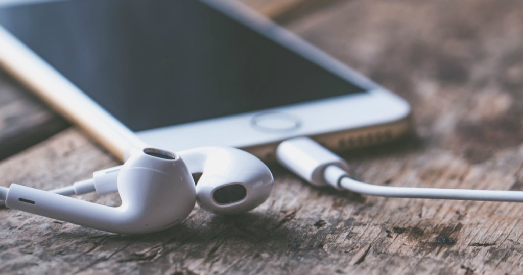 Earbuds on table next to smartphone