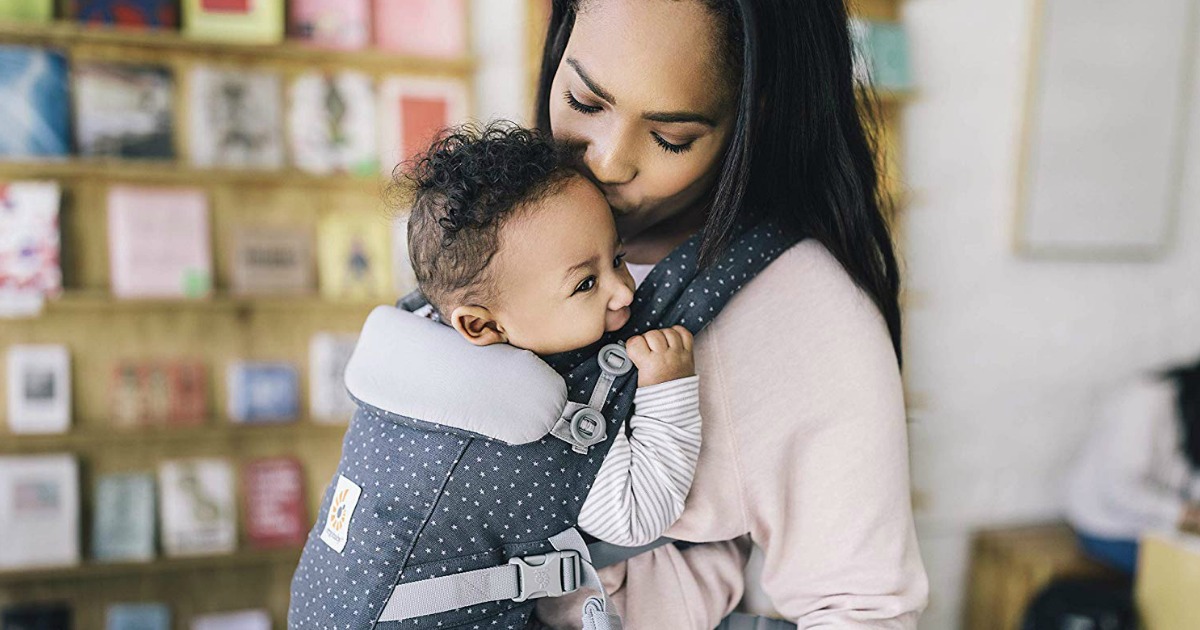 woman kissing baby in carrier