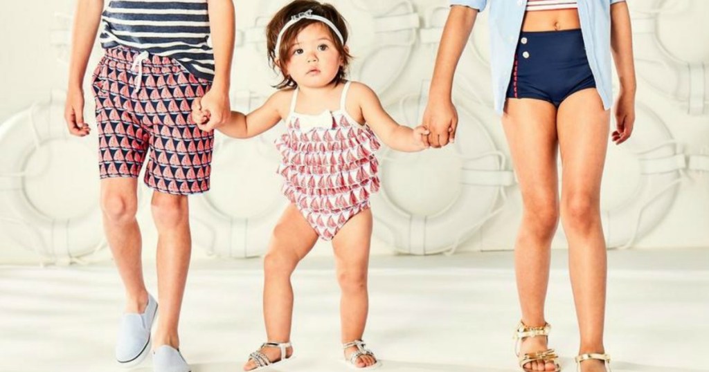 toddler girl holding in swim suit holding hands with big kids