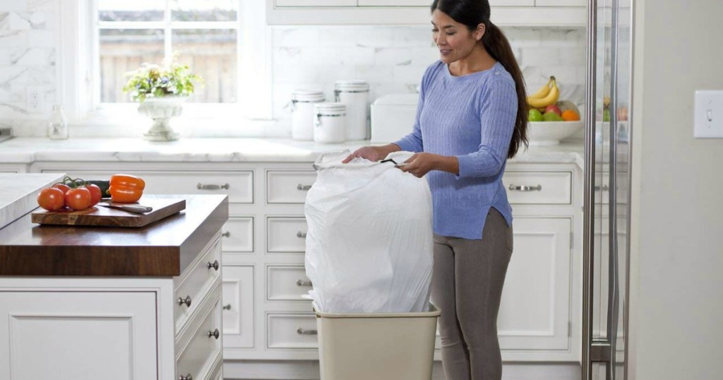 Lady in her kitchen taking out the trash