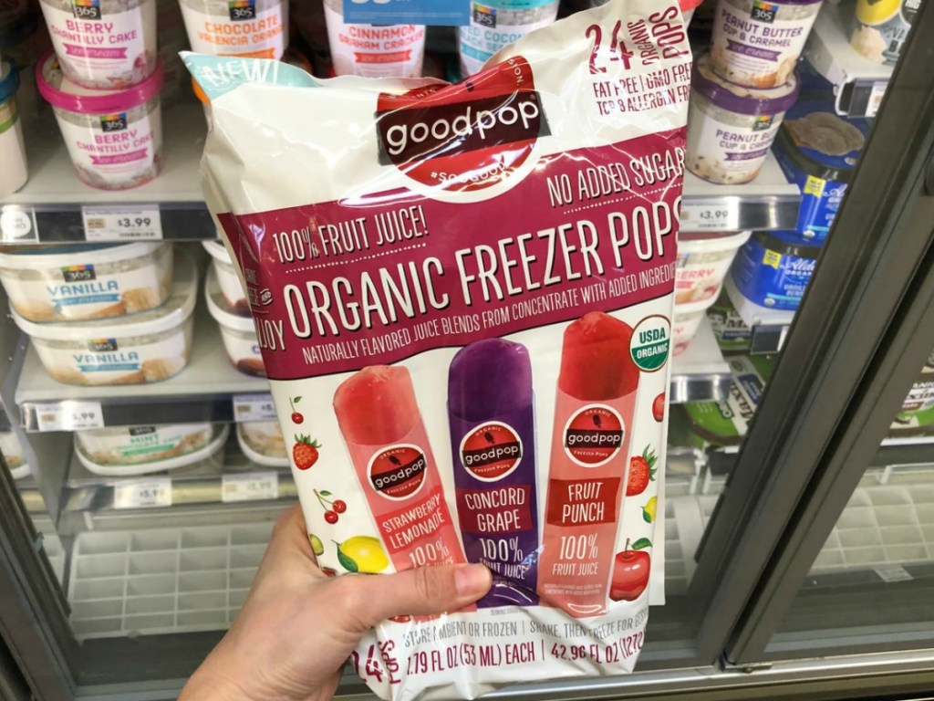 hand holding bag of popsicles by store display
