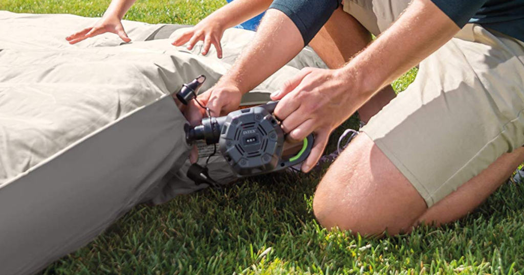 Intex Quick-Fill Rechargeable Air Pump being used on an air mattress by man wearing brown shorts