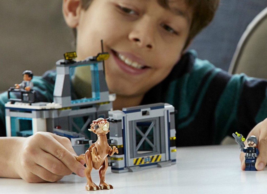 boy playing with dinosaur LEGO set