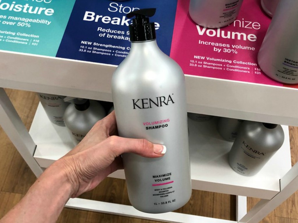 lady holding a bottle of Kenra shampoo at a store