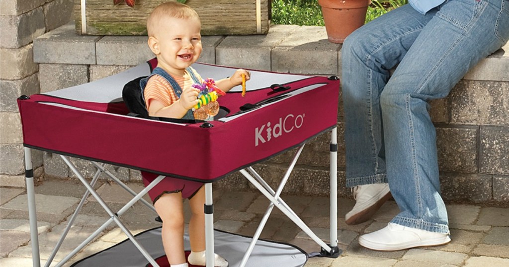 Baby in Portable activity pod while mom gardens