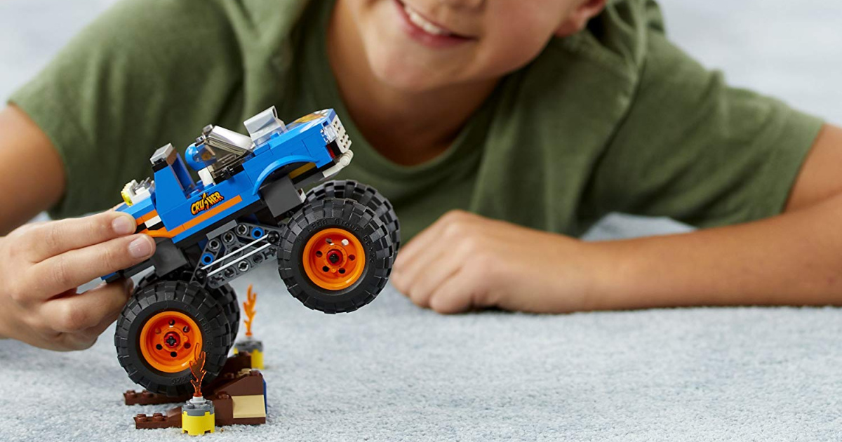 boy playing with a lego city monster truck set