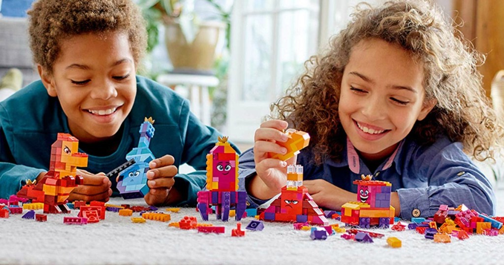 Two kids playing with a LEGO Movie 2 Queen Set