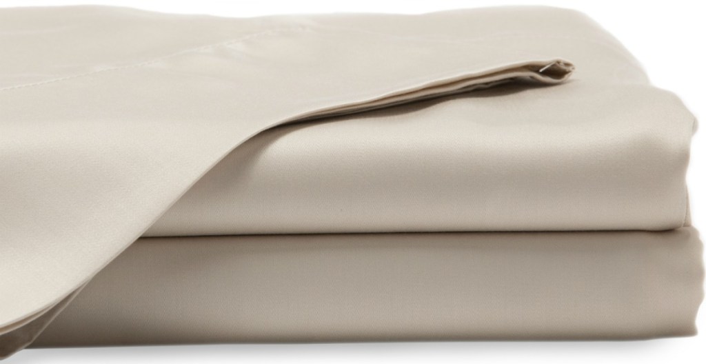 Light beige fitted and flat sheets folded and stacked