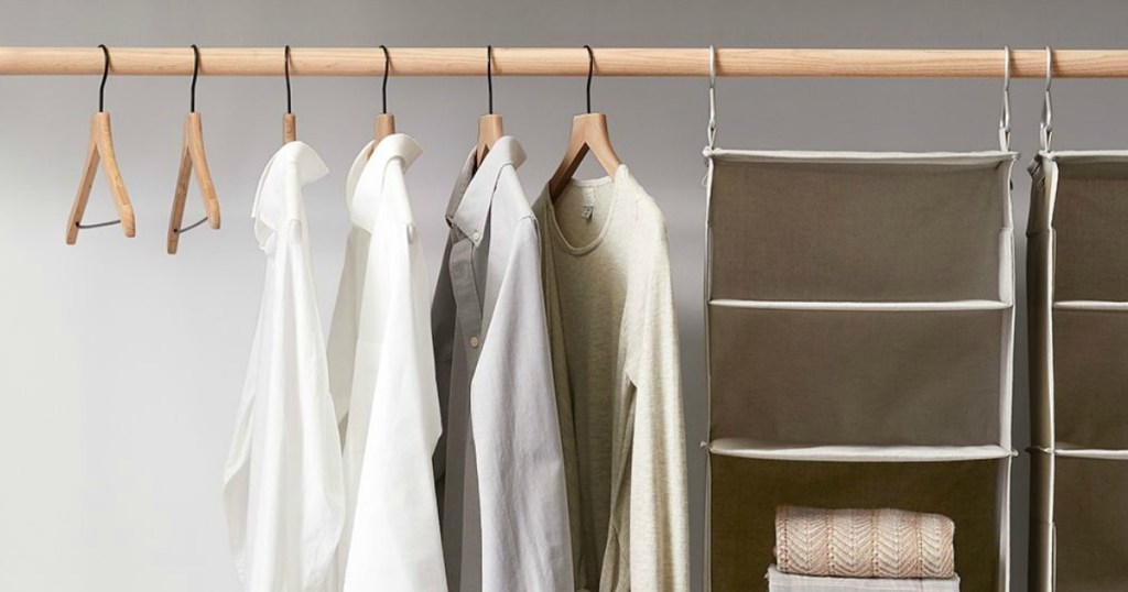 closet with wood hangers and shirts hung on them