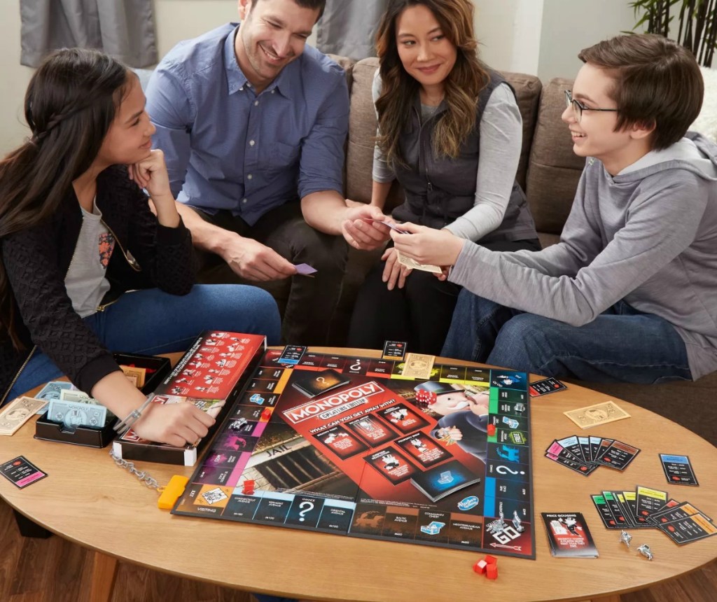 Family playing Monopoly Cheaters Edition on their coffee table