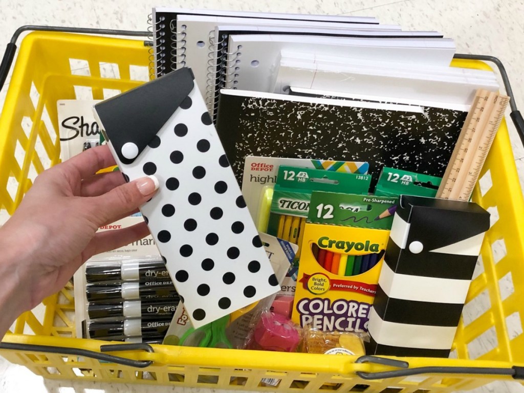 Patterned pencil boxes held up over a basket of supplies