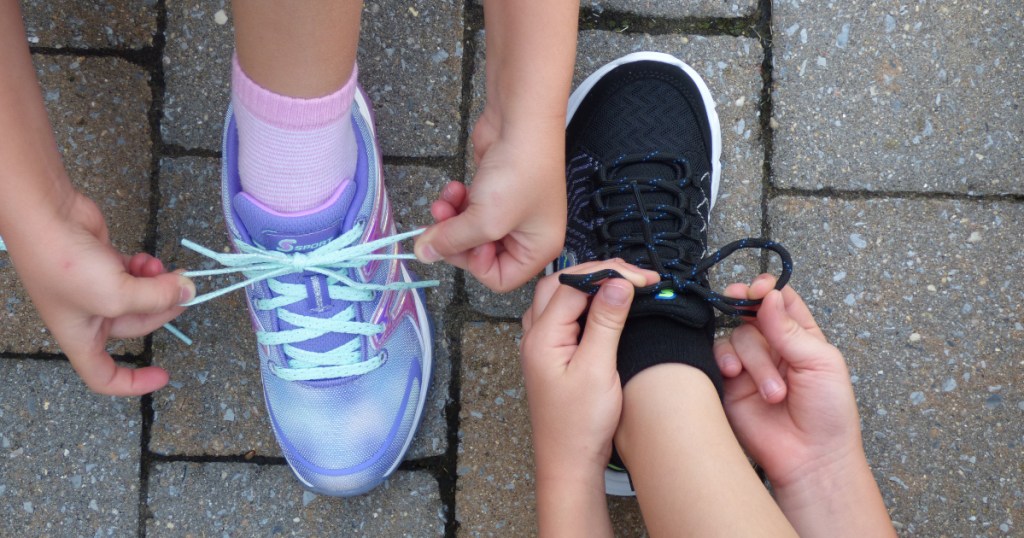 2 kids tying shoes