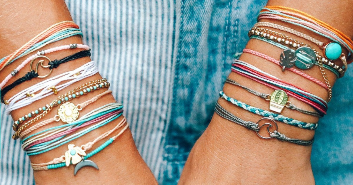 woman's wrists adorned with numerous bracelets