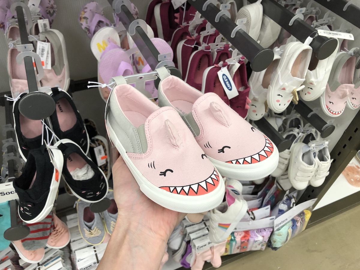 hand holding shark sneakers