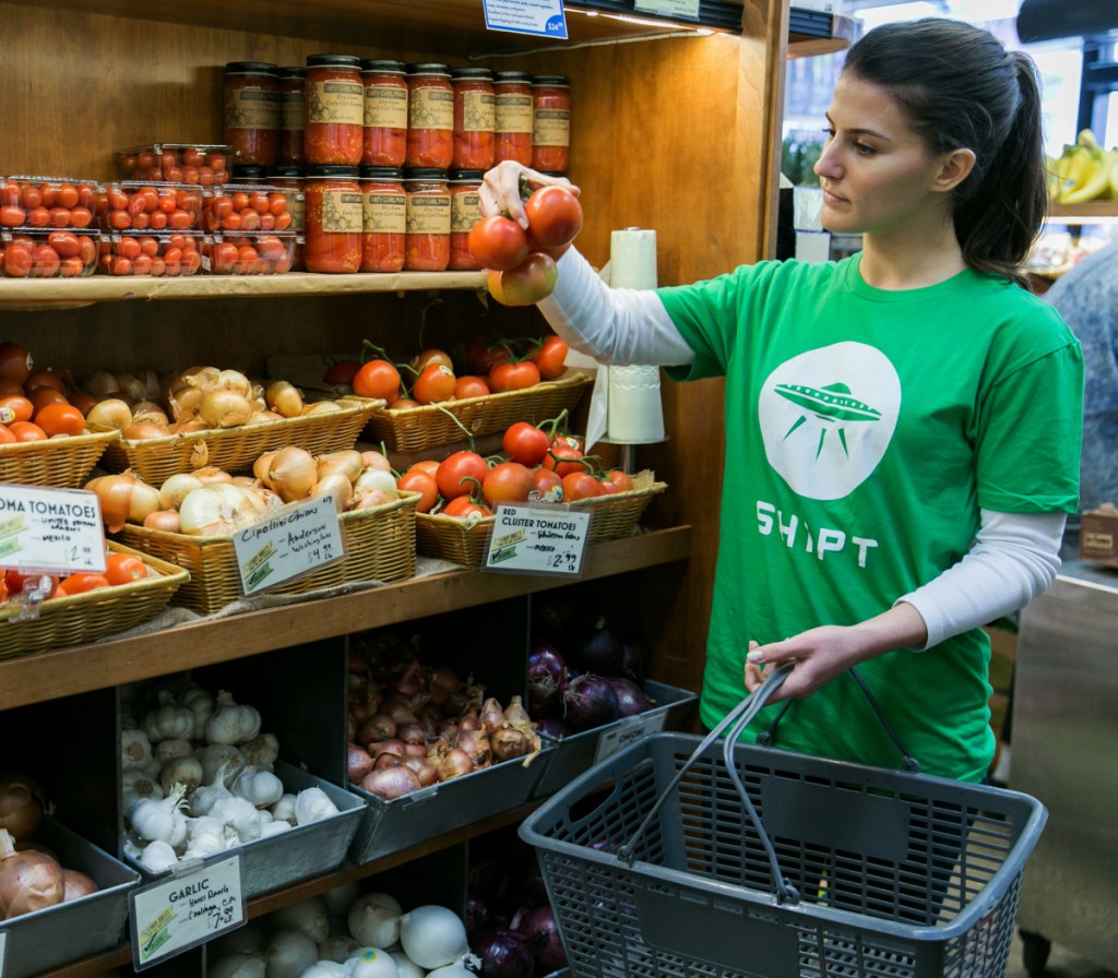 Shipt shopper holding tomatoes and basket