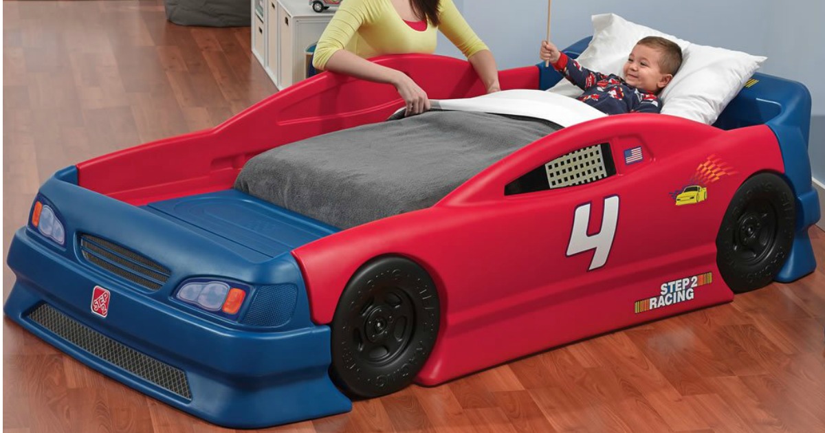 toddler boy lying down in Step2 Stock Car Convertible Bed