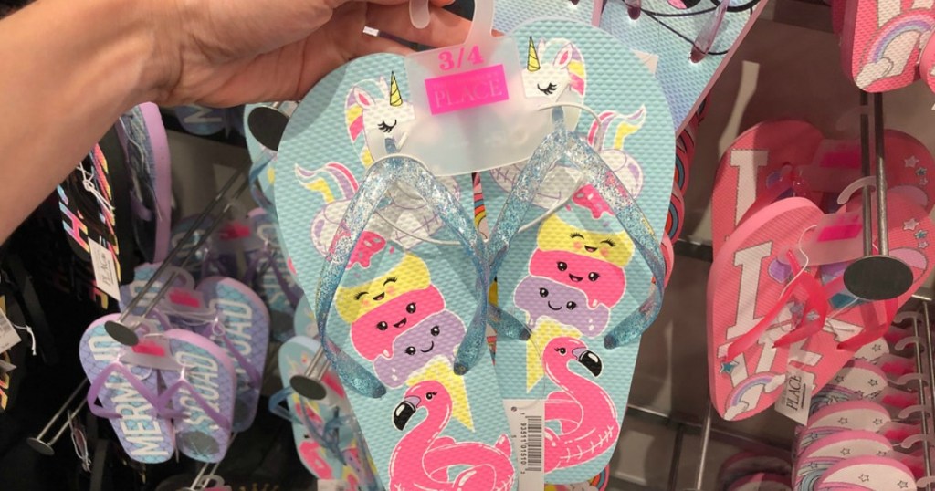 lady holding The Children's Place flip flops at the store