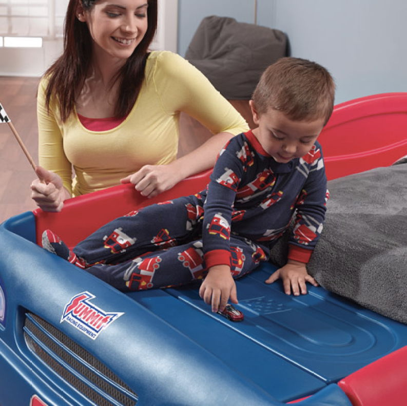 Toddler boy playing with car on Step2 Stock Car Convertible bed