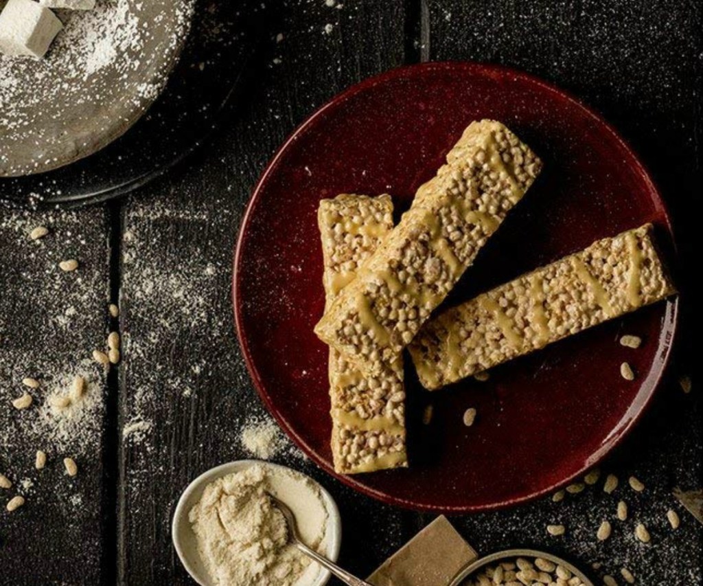 Three protein crisp bars on table top with ingredients