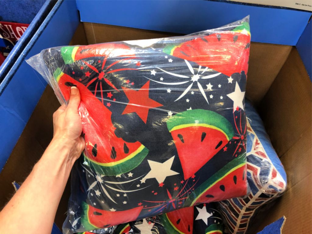 womans hand holding up watermelon firework pillow at home depot