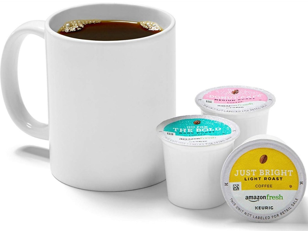 cup of coffee sitting by 3 coffee pods