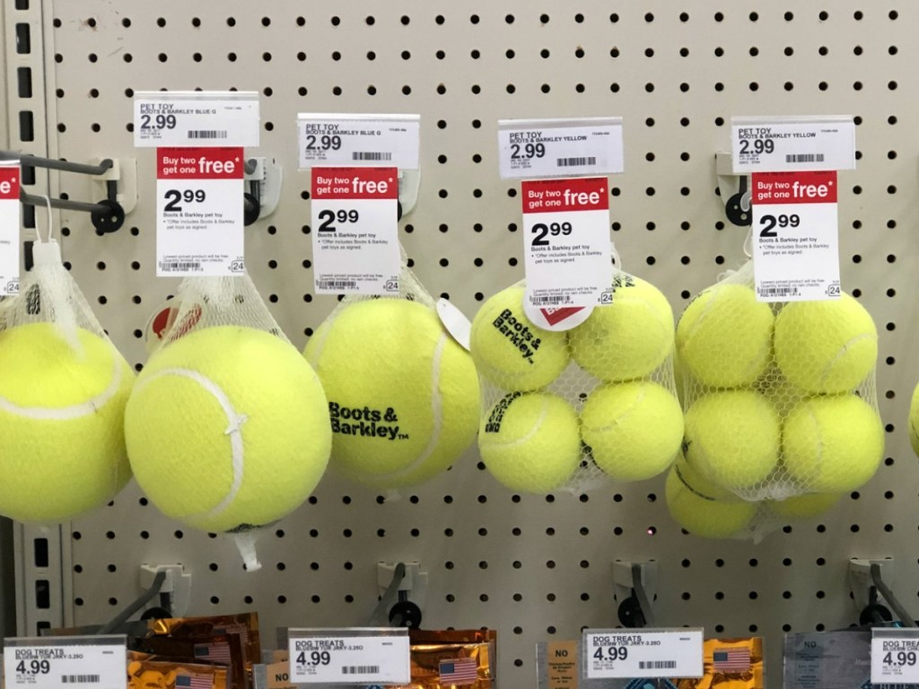 yellow balls that are pet toys hanging on store display