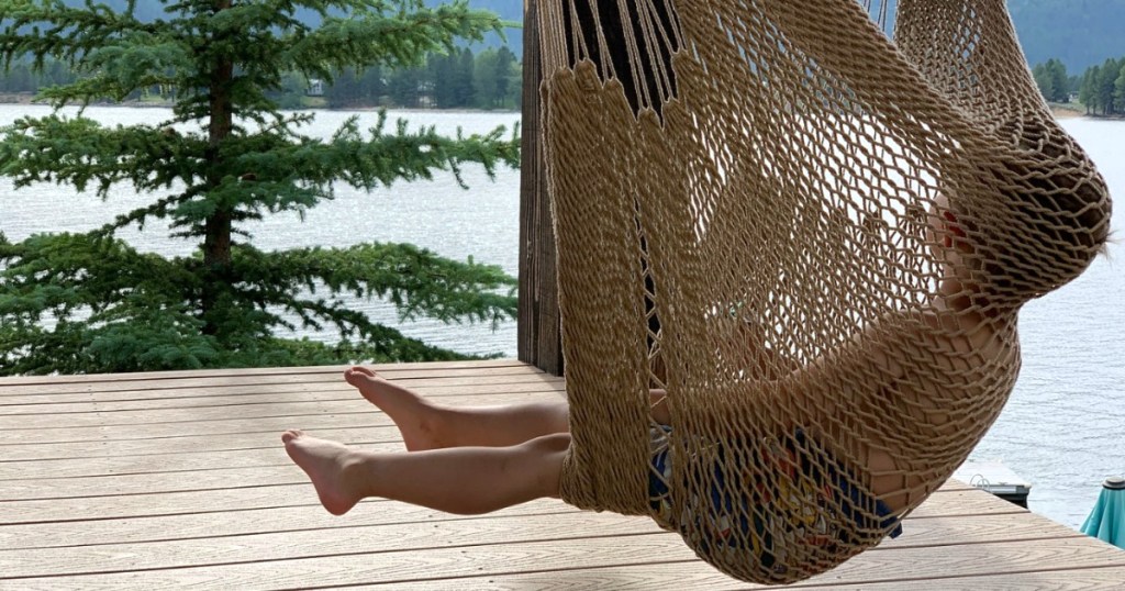 little boy in hammock chair swinging outside 