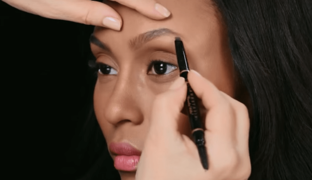 woman getting her eyebrows filled with brow pencil