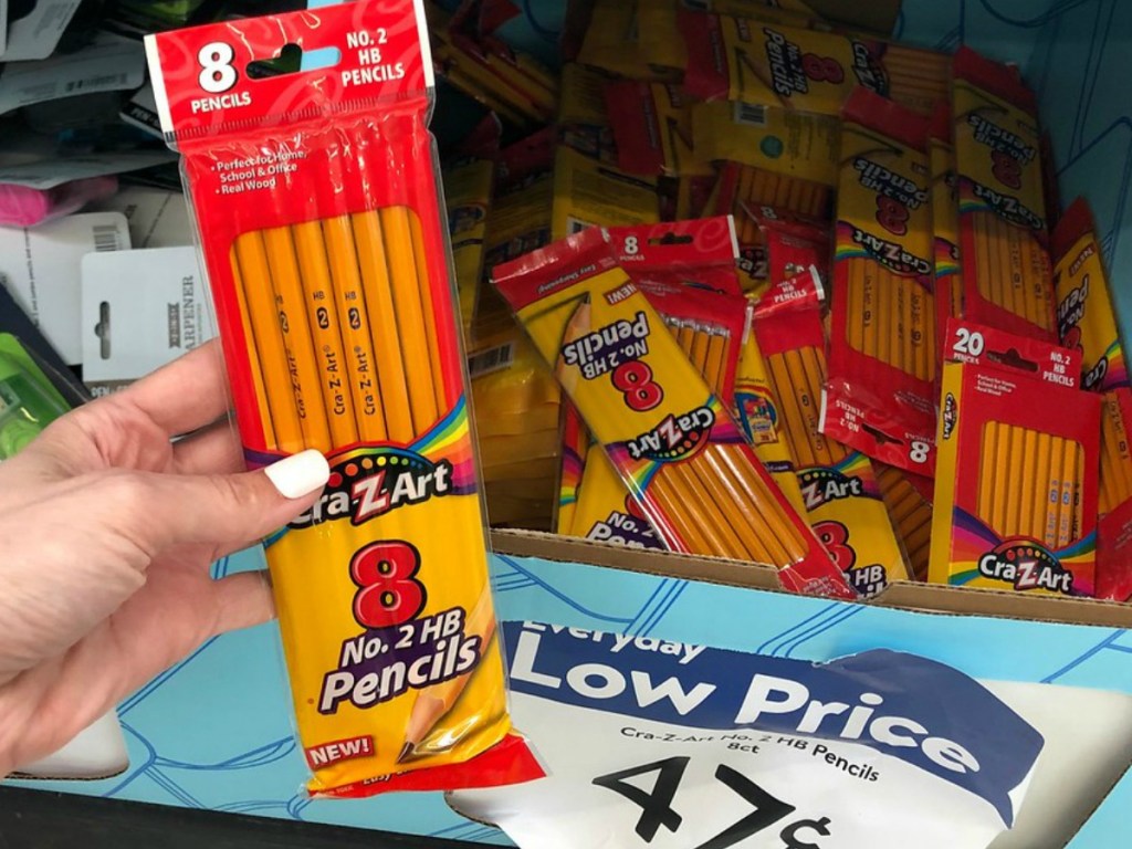 hand holding package of pencils by store display