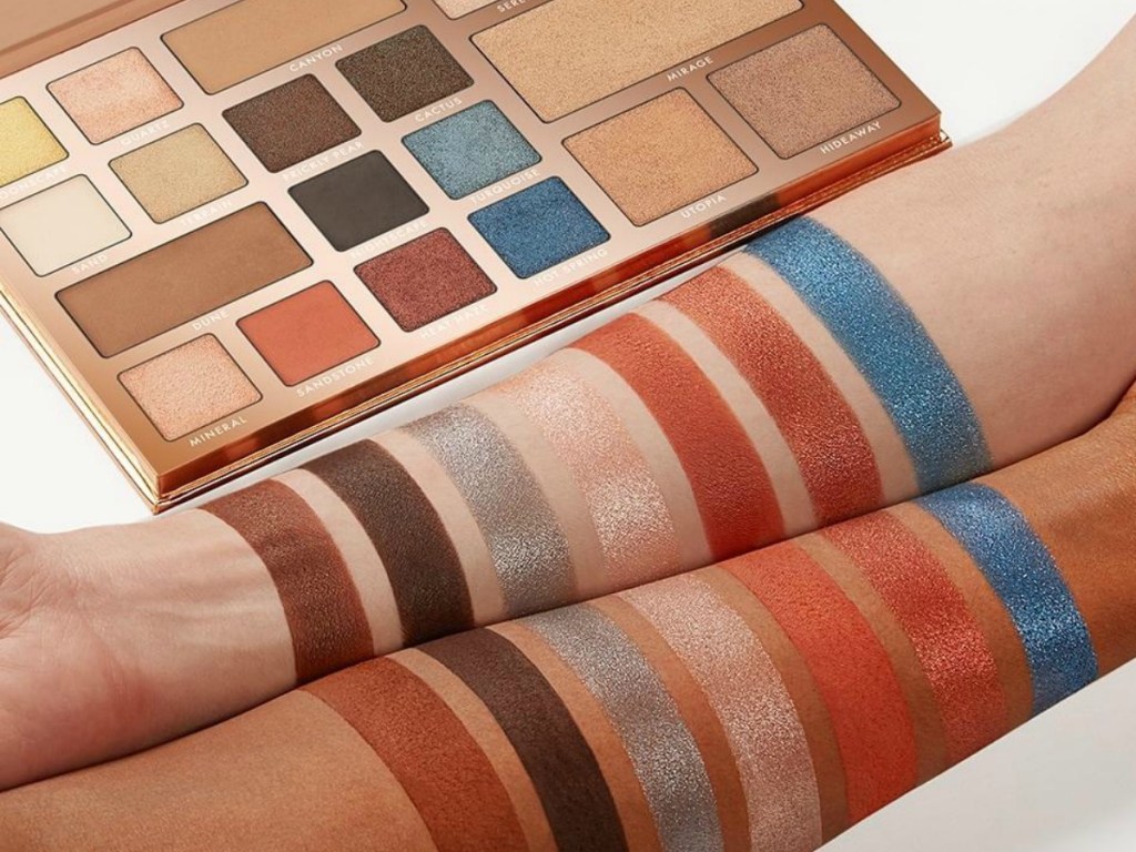 arms with make up colors on them next to make up palette