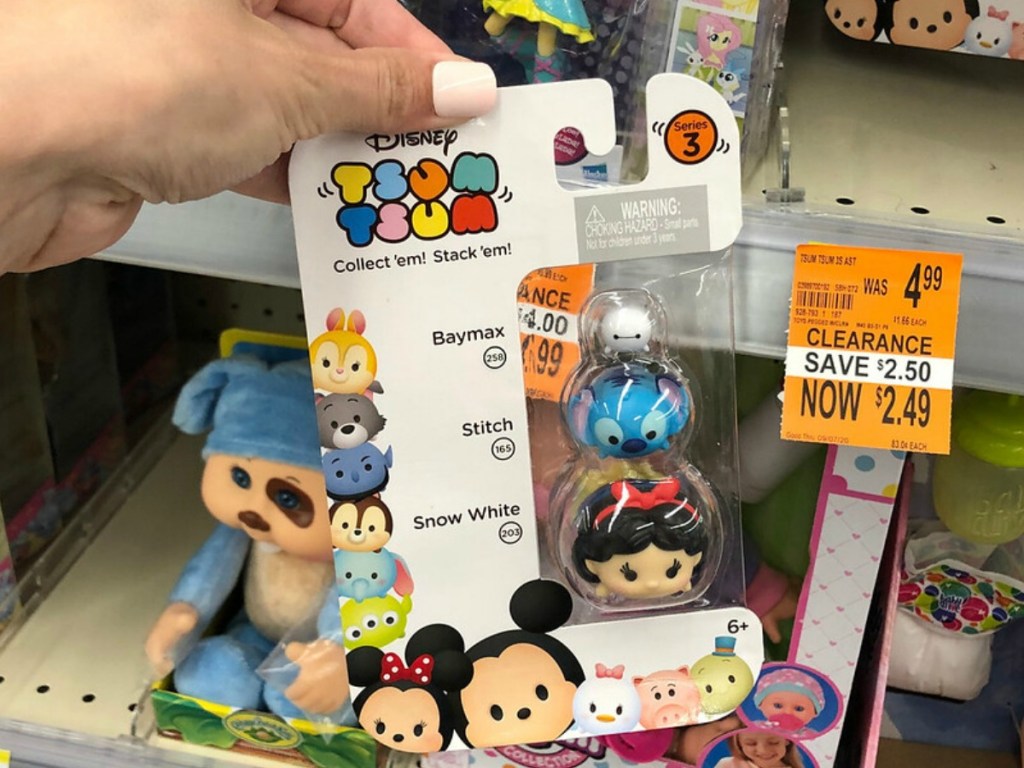 small Disney toys in package held by hand in store