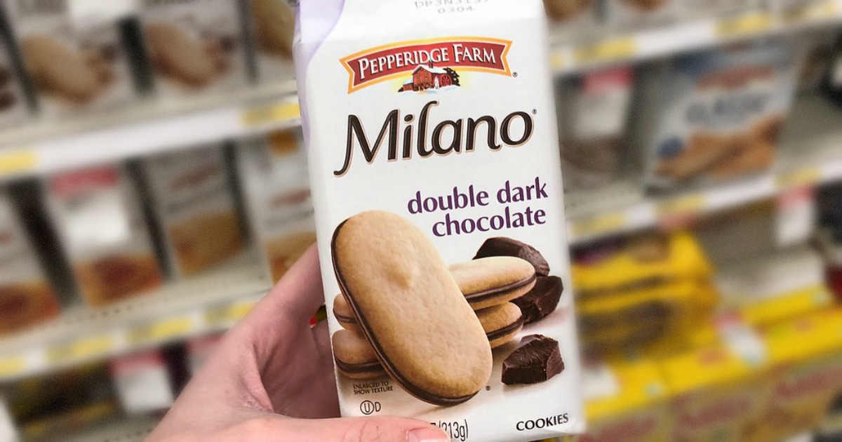 hand holding bag of cookies by store display