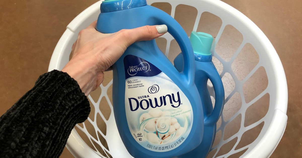 woman putting Downy fabric softener in laundry basket